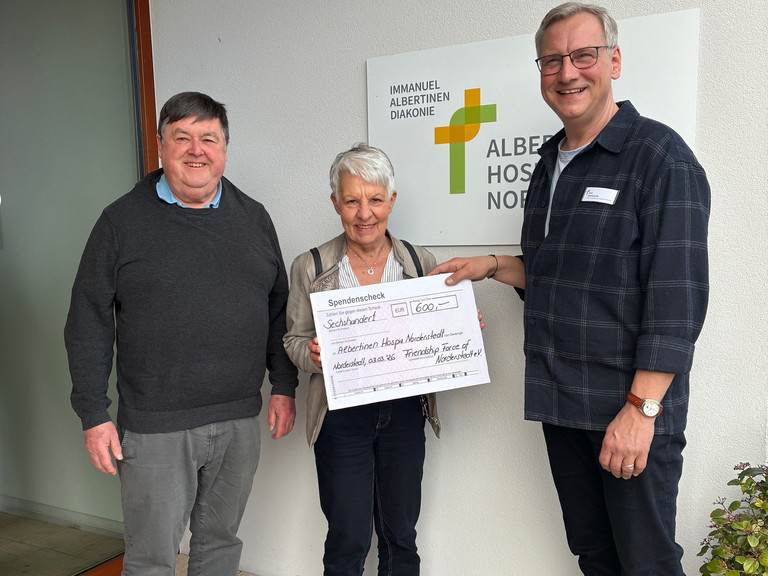 Jürgen Czischke, Susanne Rummel und Jens Klindworth bei der Scheckübergabe im Eingangsbereich des Albertinen Hospiz Norderstedt