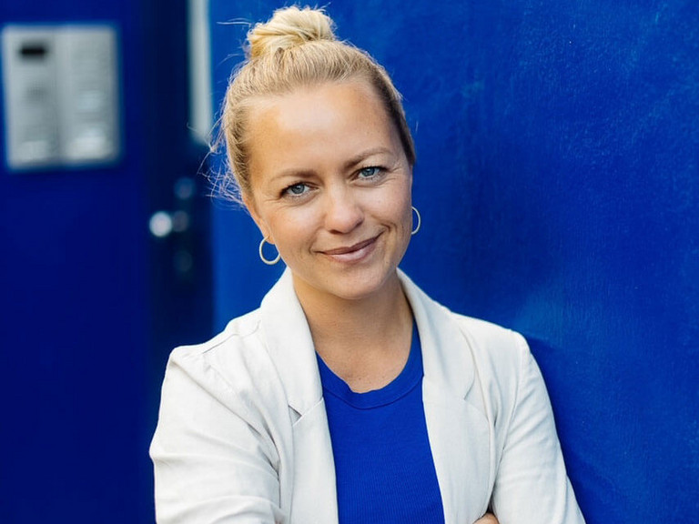 Die ehrenamtliche Mitarbeiterin Jennifer Mattes steht an eine Wand gelehnt - Albertinen Hospiz Norderstedt