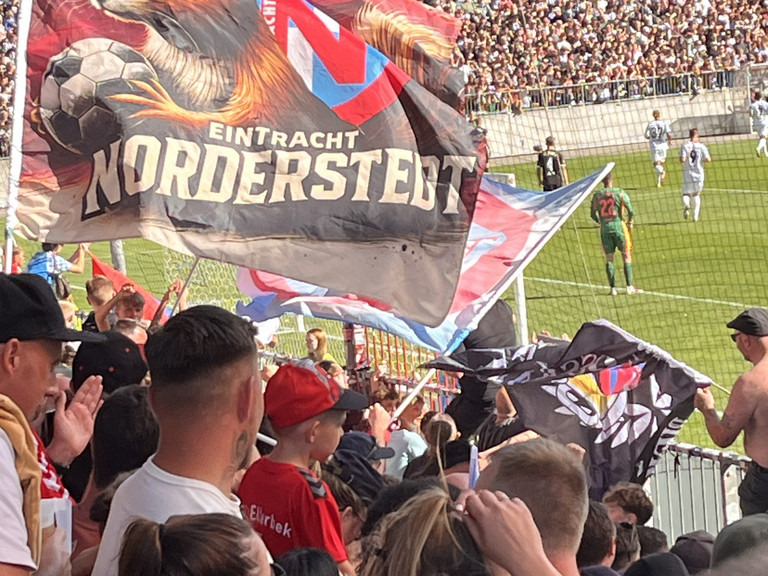 Fahne im Fanblock des FC Eintracht Noderstedt im Stadion am Millerntor gegen den FC St. Pauli bei einem Fußballspiel mit der Aktion Pfandbecherspende für das Diakonie Hospiz Norderstedt